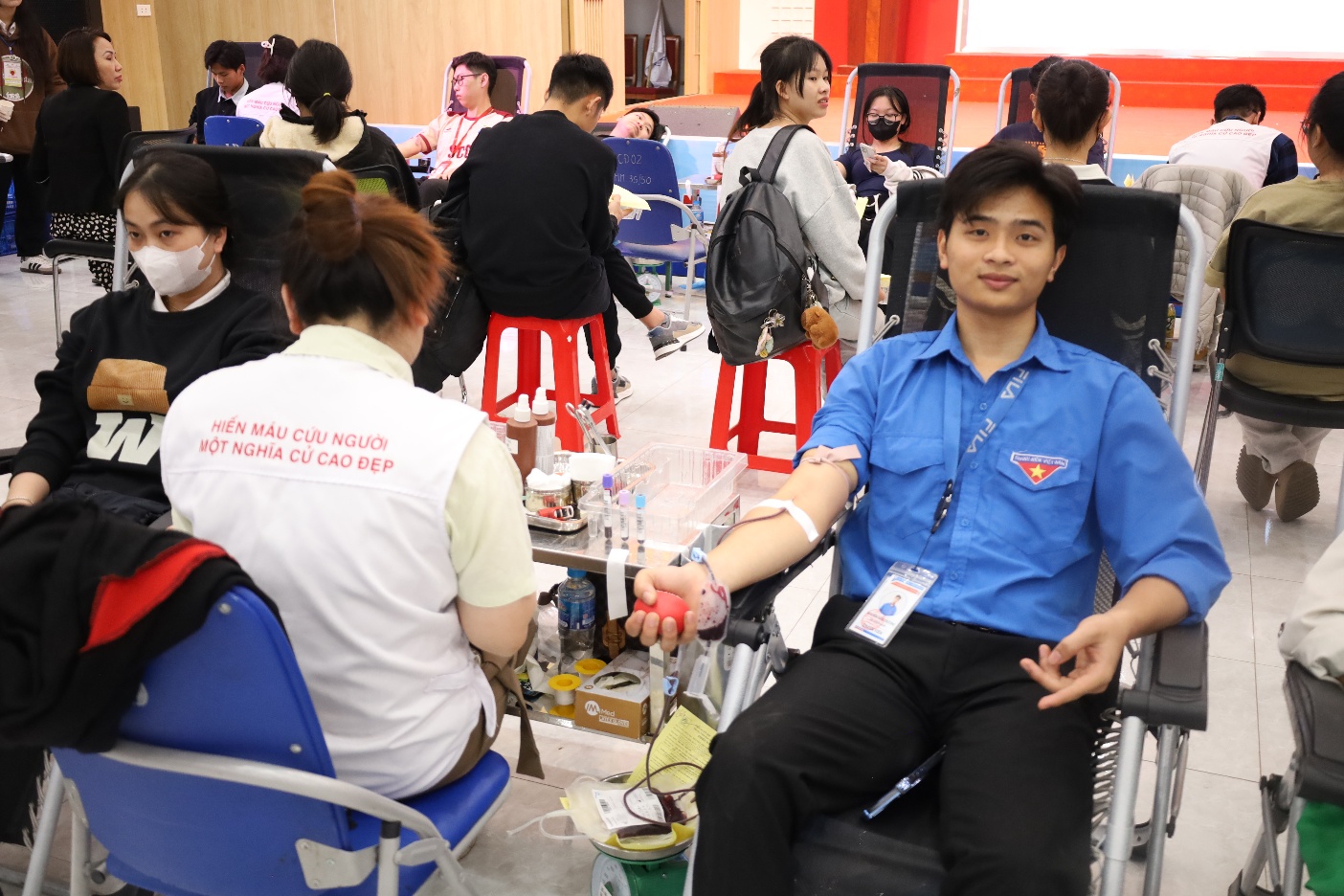 A person in a wheelchair in a room with other people

Description automatically generated