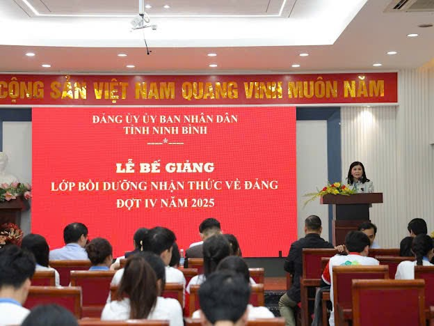 A person standing at a podium in front of a group of people Description automatically generated