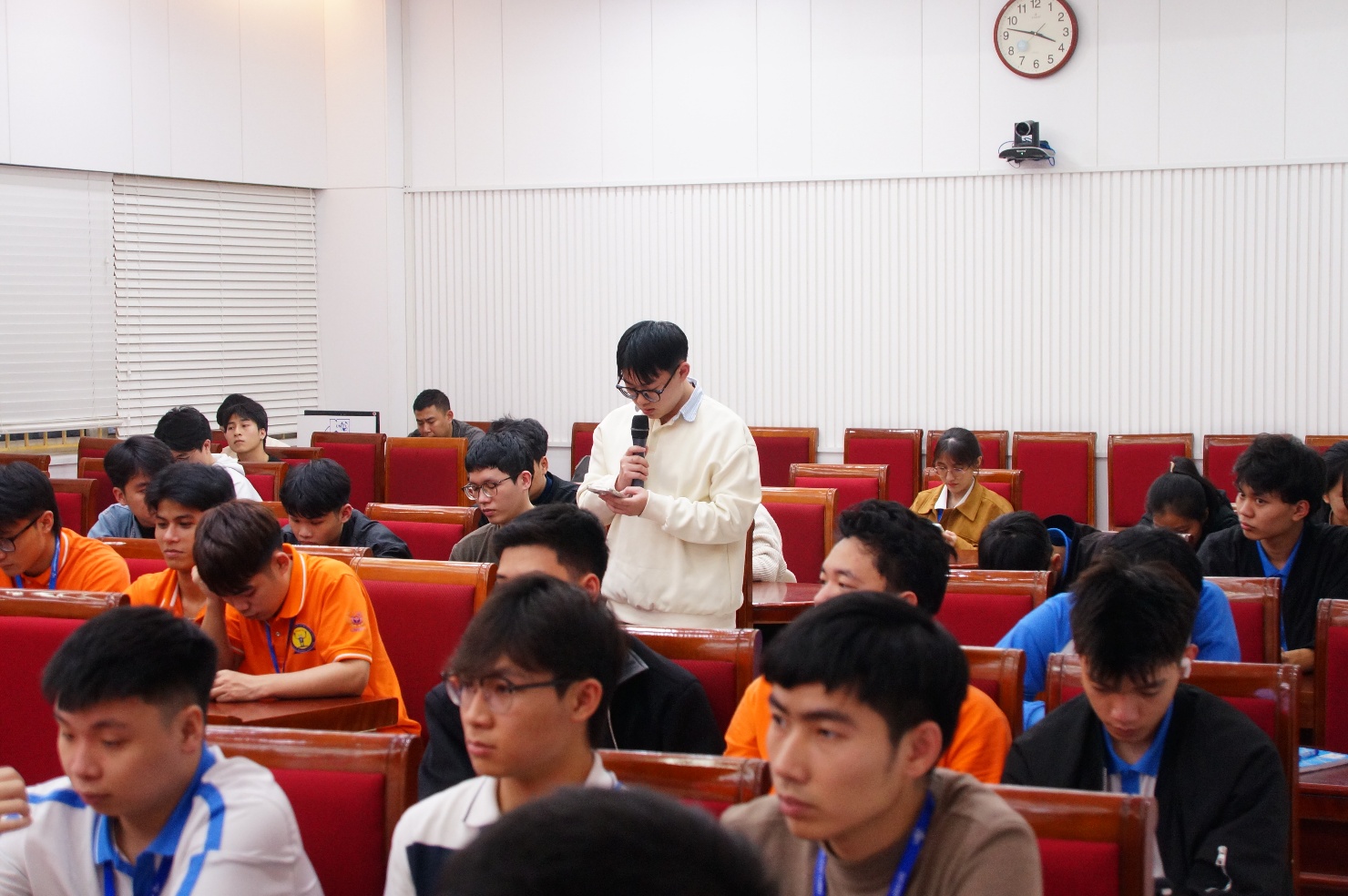 A group of people in a lecture hall Description automatically generated