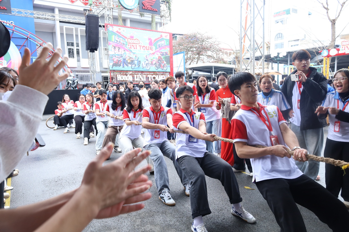 A group of people in a tug of war Description automatically generated