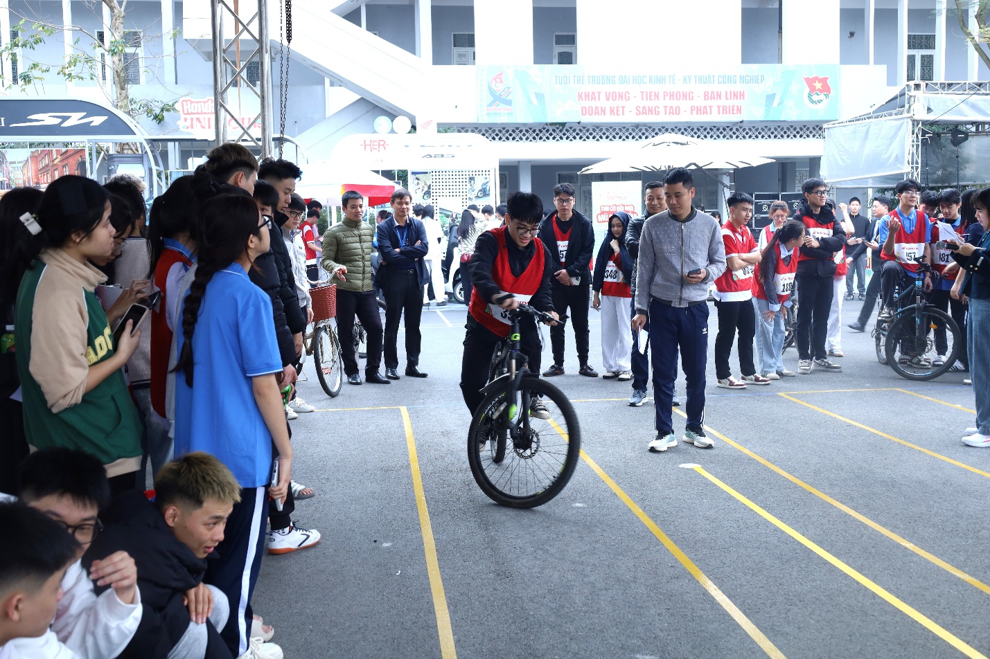 A group of people standing around a bicycle Description automatically generated