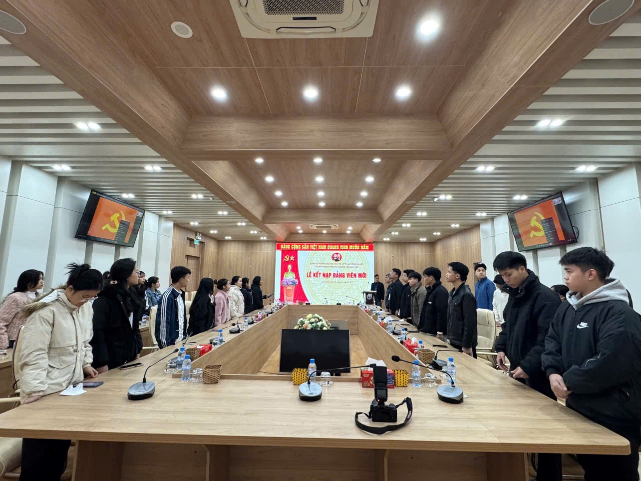 A group of people standing in a room
Description automatically generated