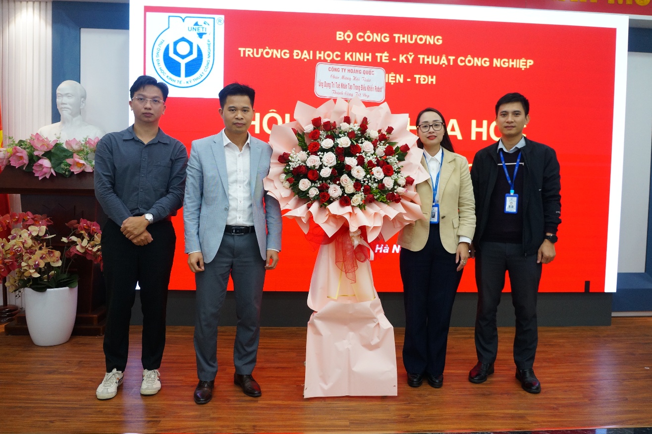 A group of people standing in front of a large sign Description automatically generated