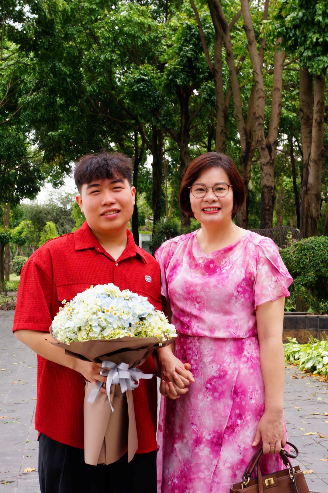 A person and person holding flowers
Description automatically generated