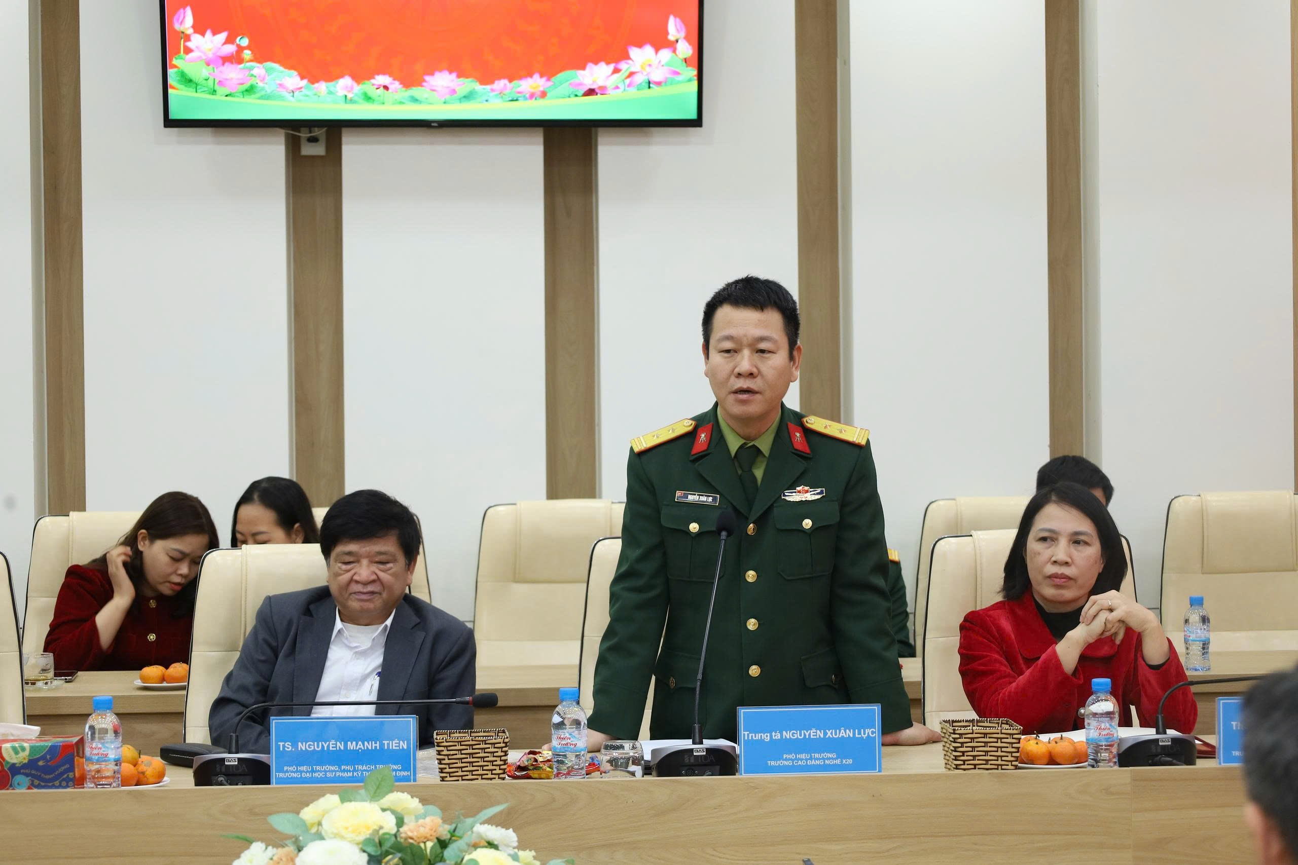 A person in a military uniform standing in front of a group of people Description automatically generated