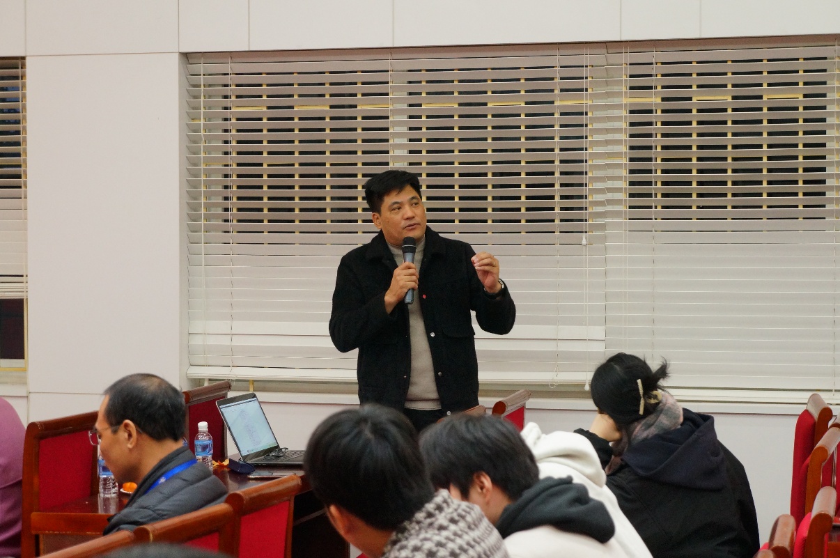 A person standing in front of a group of people

Description automatically generated