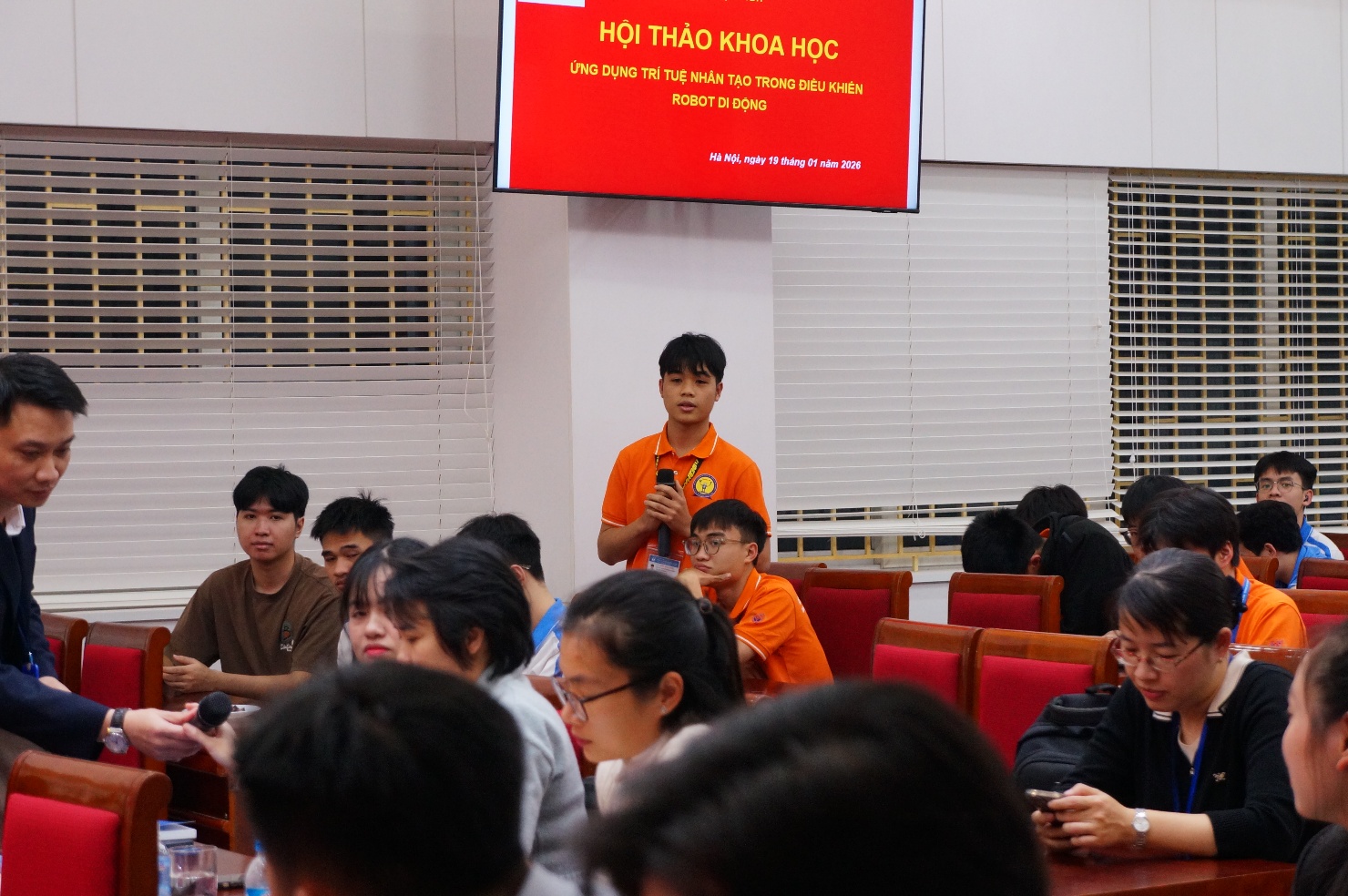 A person standing in front of a group of people Description automatically generated