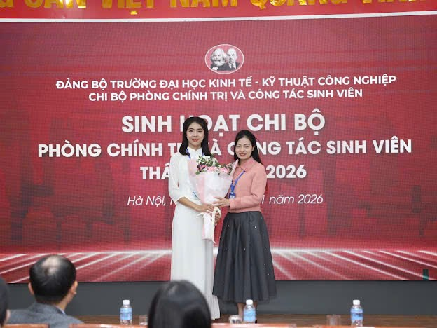 Two women standing in front of a banner
Description automatically generated