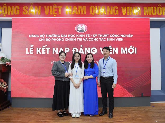 A group of people standing in front of a sign Description automatically generated