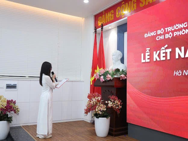 A person in a white dress standing in front of a large sign Description automatically generated