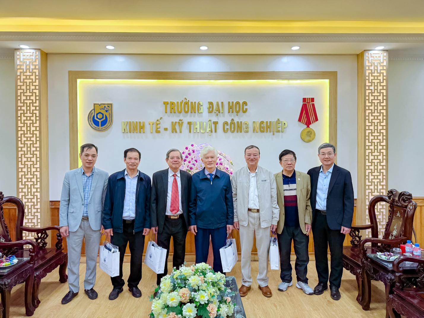 A group of men standing in front of a sign Description automatically generated