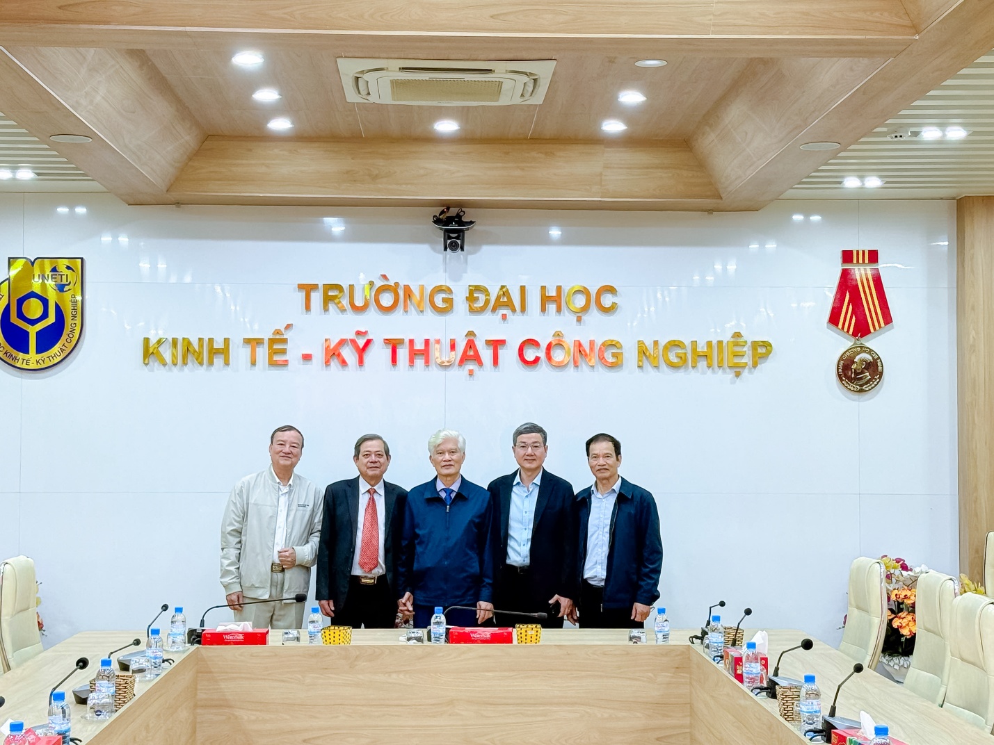 A group of men standing in front of a sign Description automatically generated