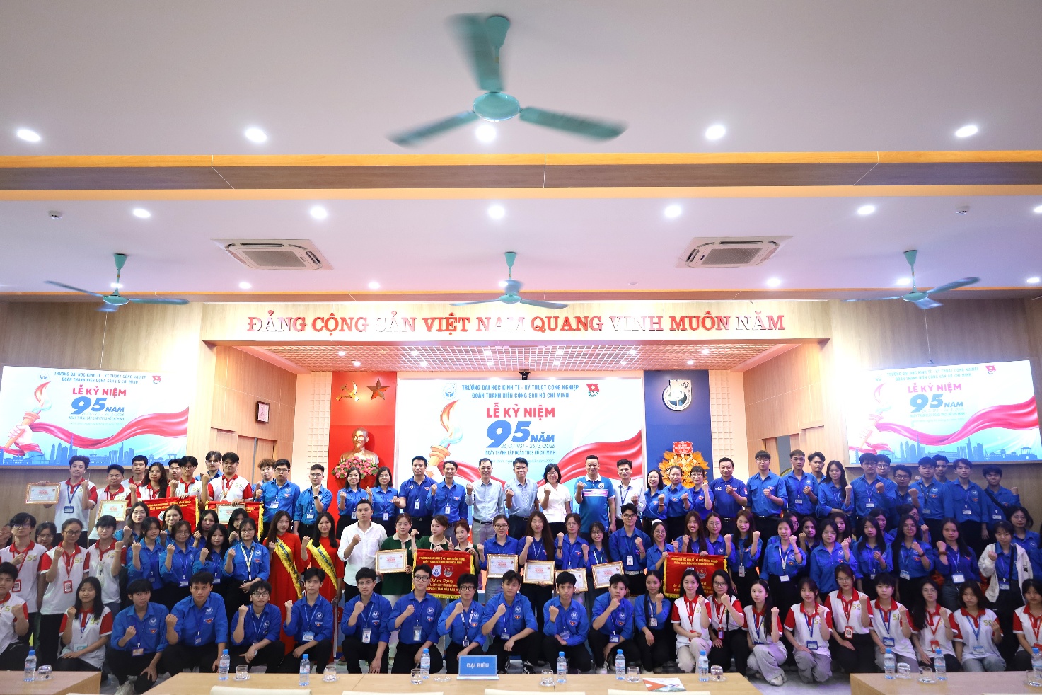 A group of people in blue shirts Description automatically generated