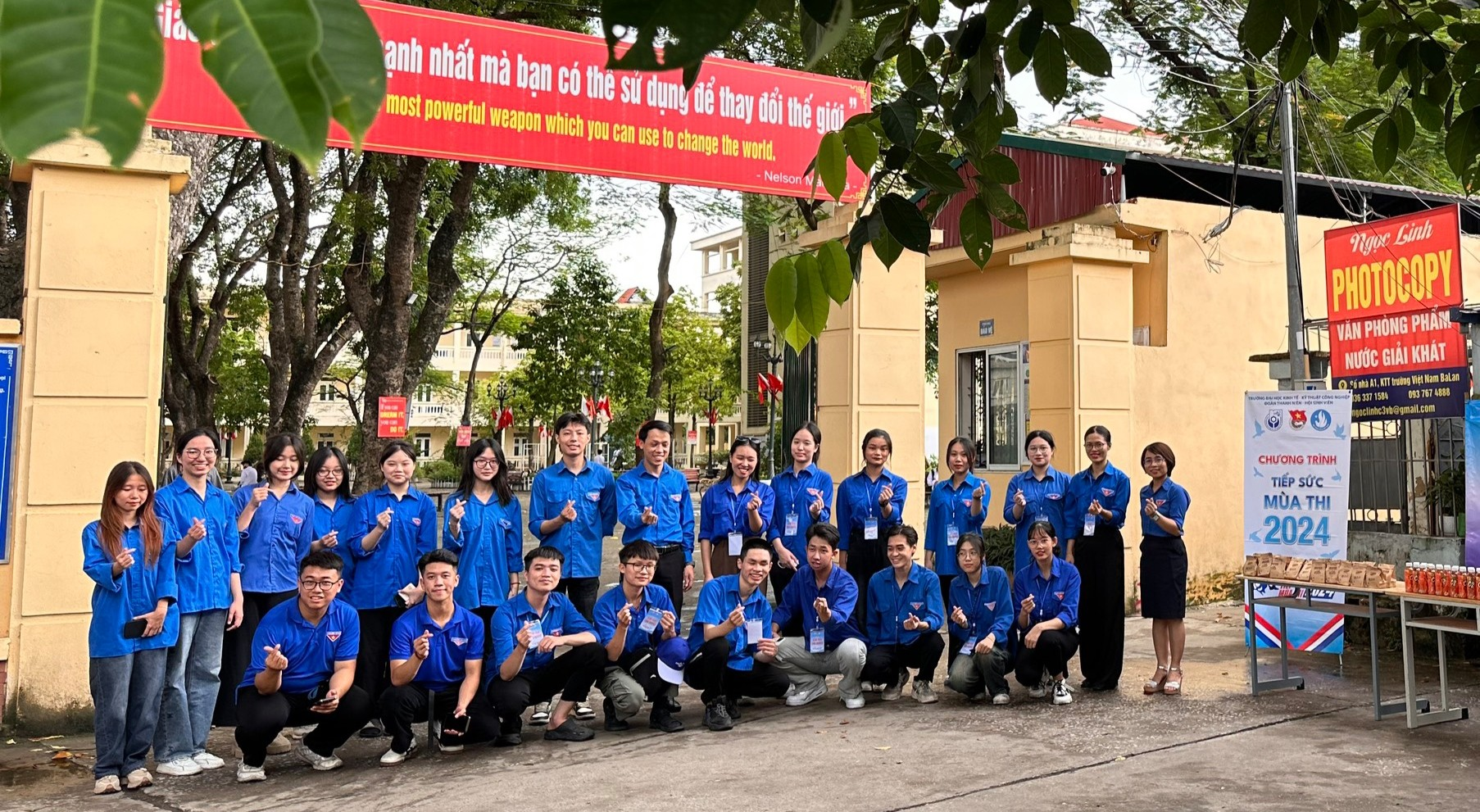 A group of people in blue shirts posing for a photo
Description automatically generated