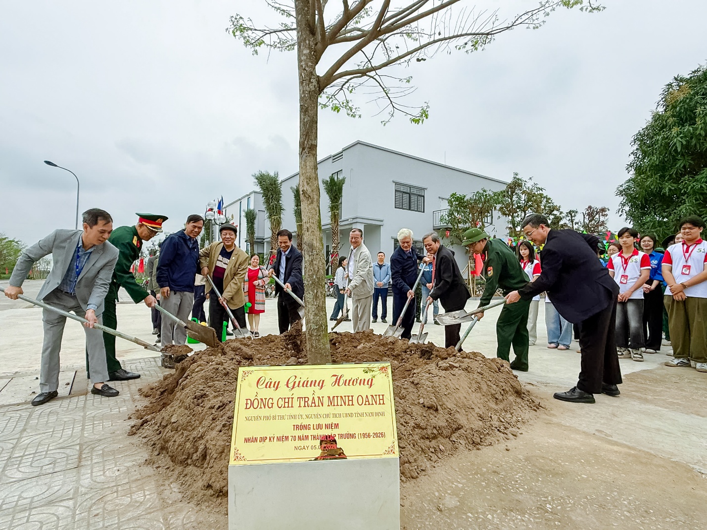 A group of people planting a tree Description automatically generated