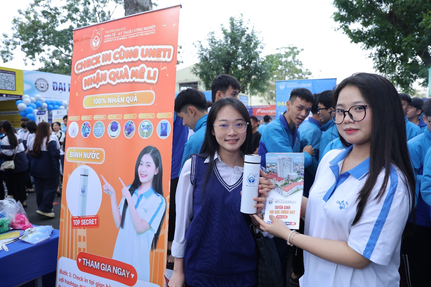 A group of people standing next to a sign Description automatically generated