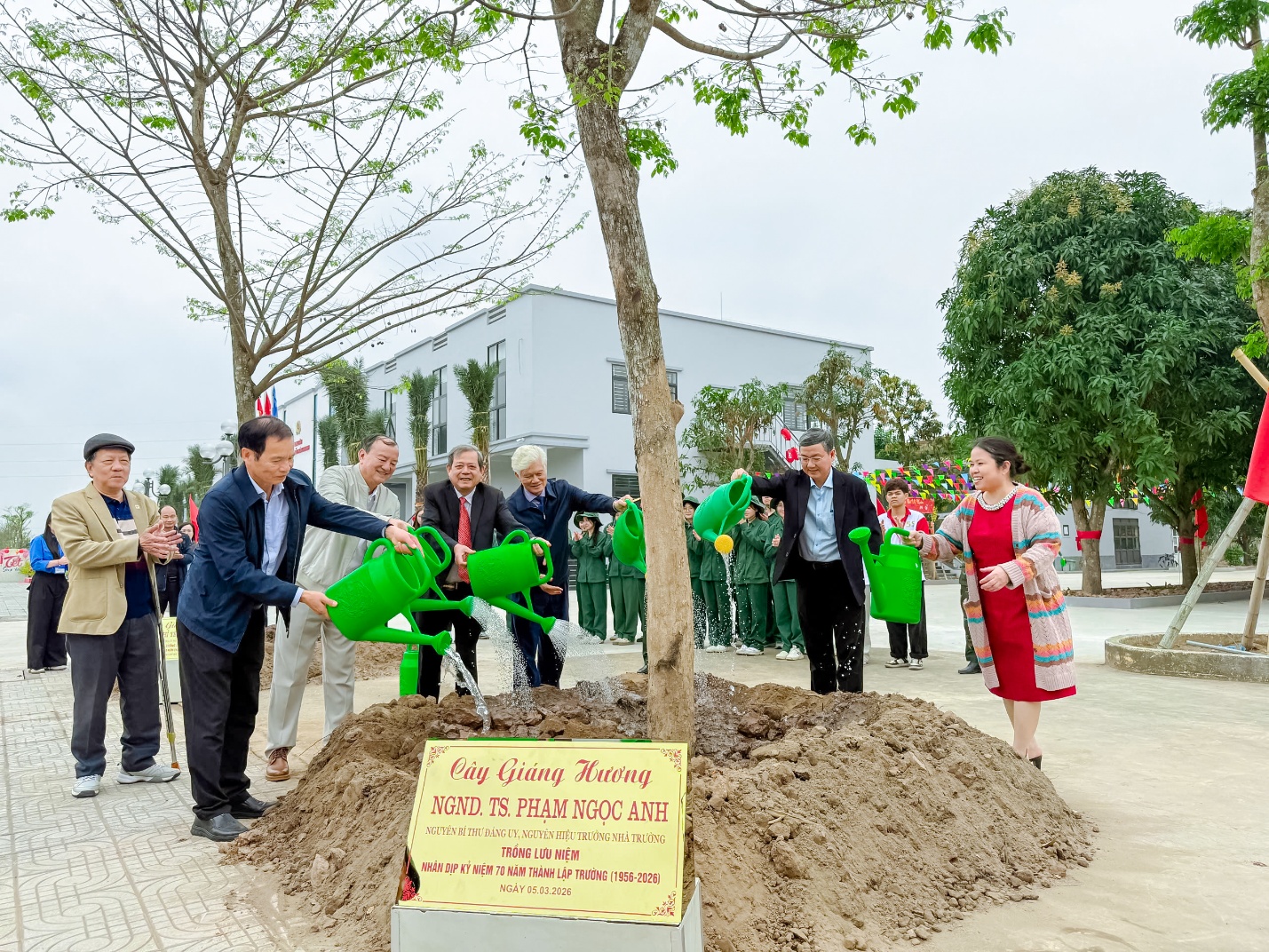 A group of people watering trees Description automatically generated