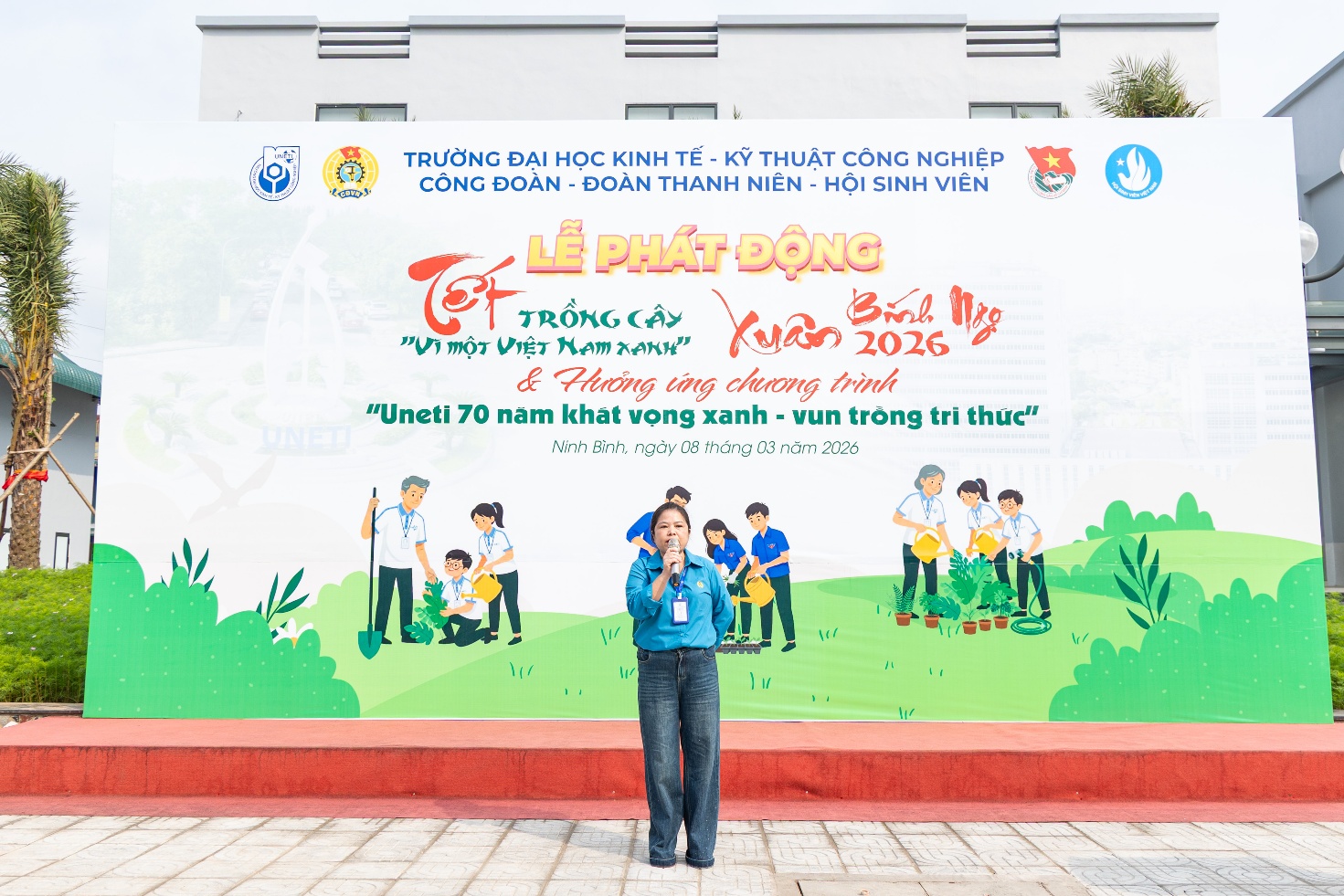 A person standing in front of a banner Description automatically generated
