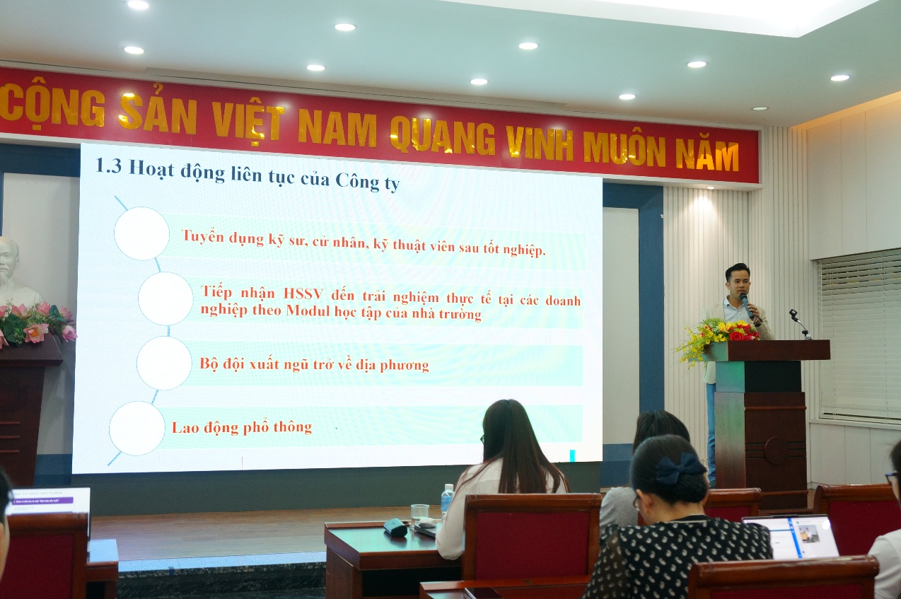 A person standing in front of a large screen
Description automatically generated