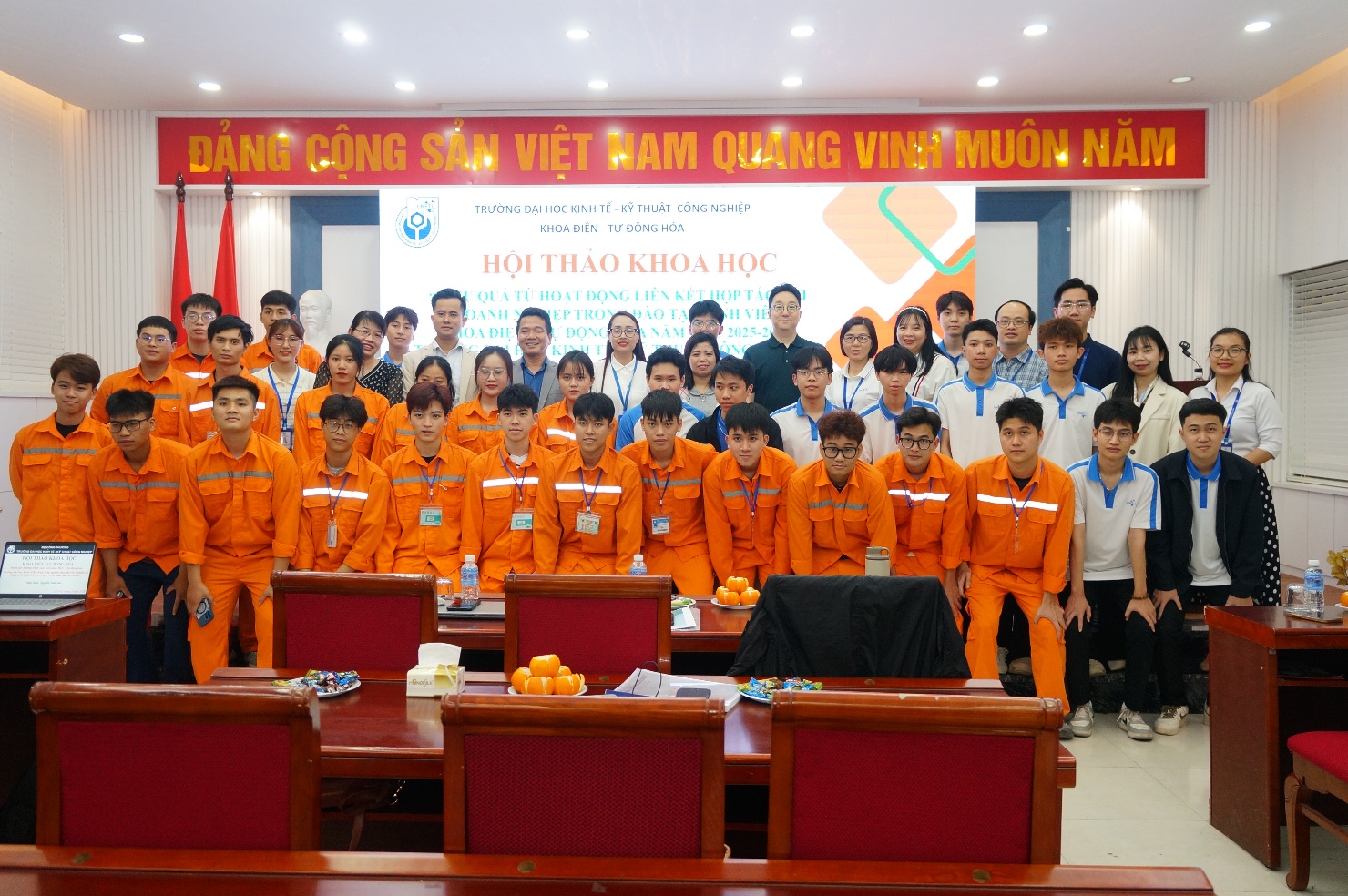 A group of people in orange jumpsuits posing for a photo Description automatically generated