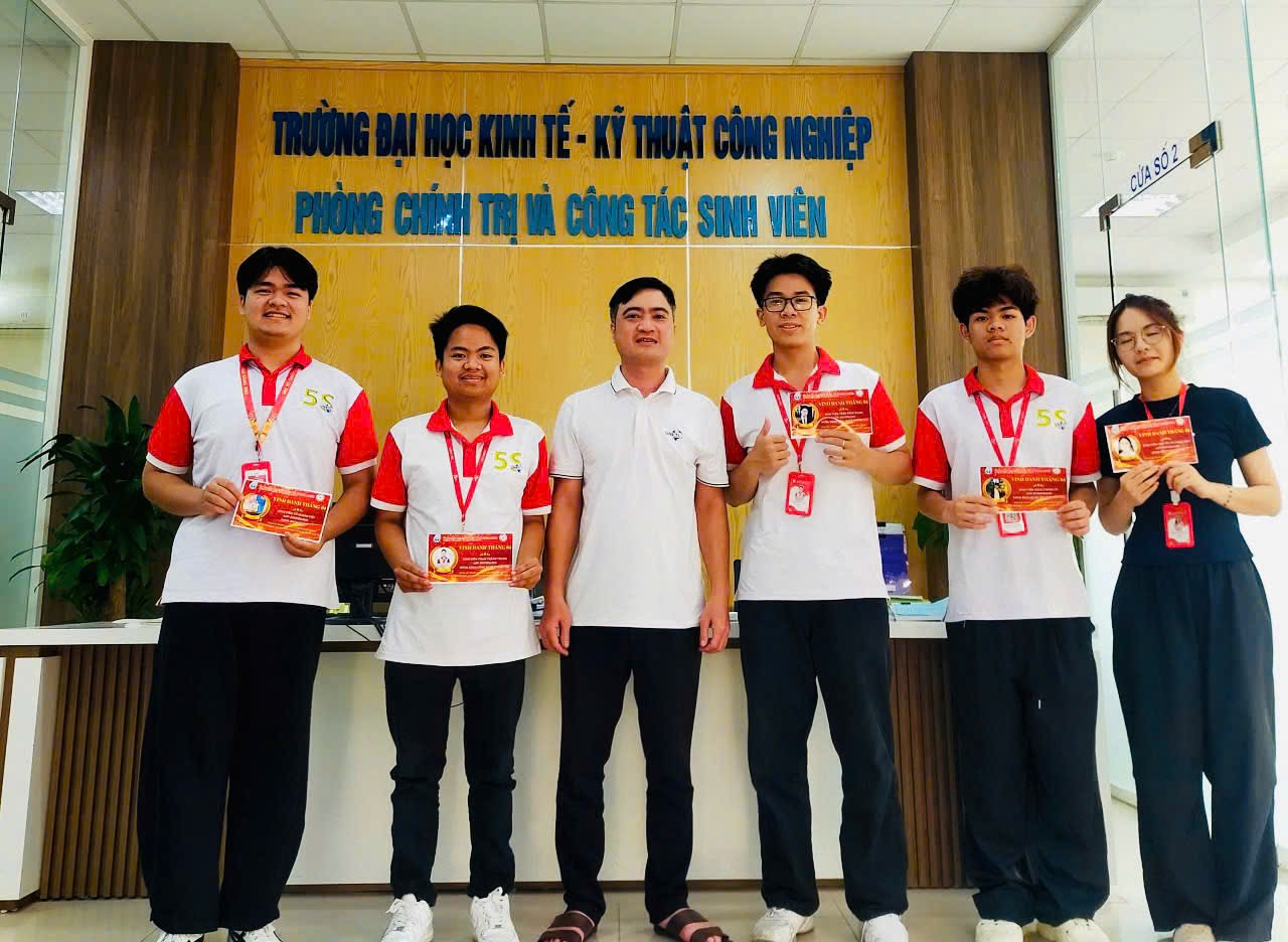 A group of people standing in front of a sign Description automatically generated