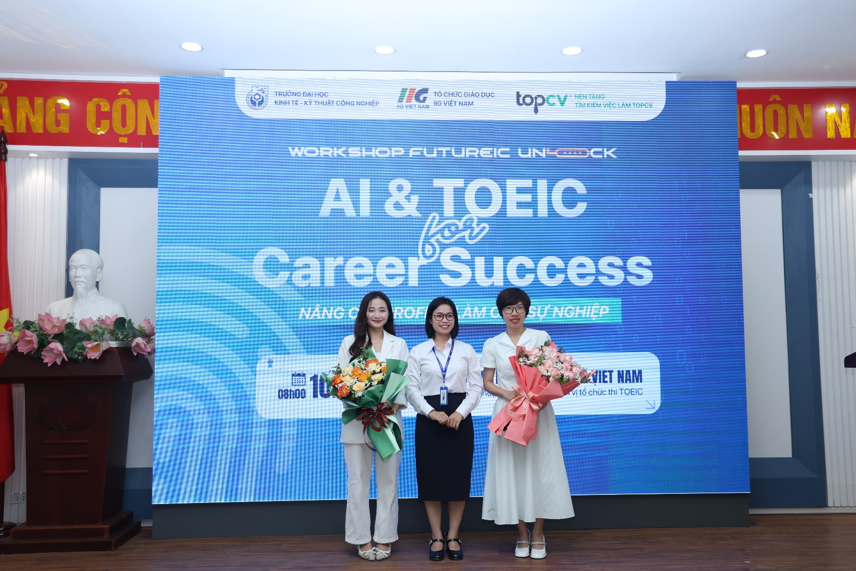 A group of women standing in front of a large sign Description automatically generated
