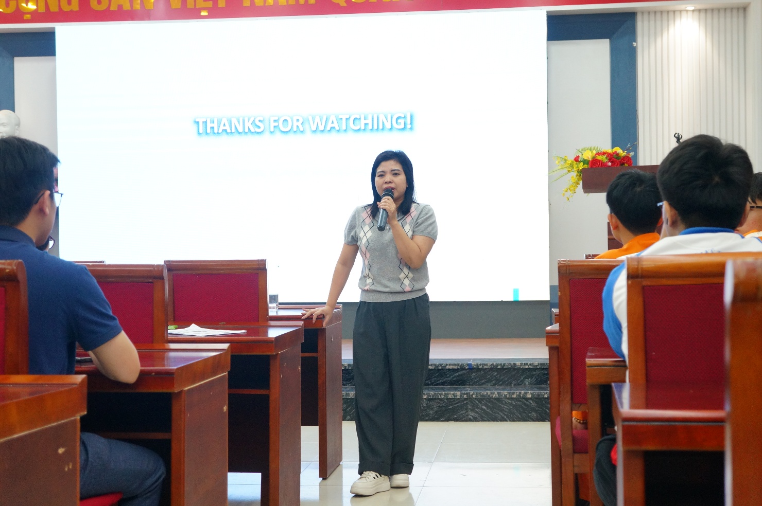 A person speaking into a microphone Description automatically generated