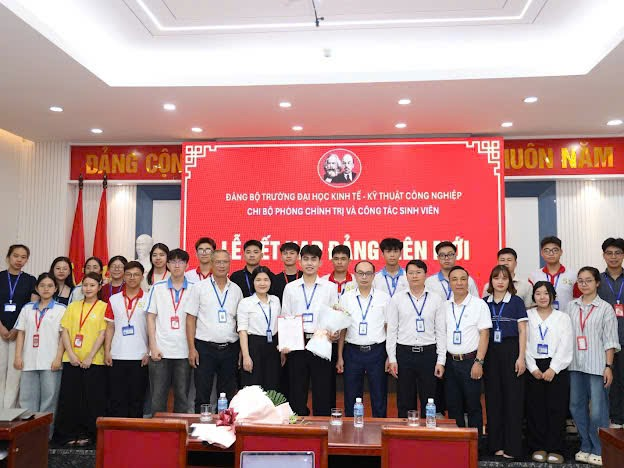 A group of people standing in front of a red banner
Description automatically generated
