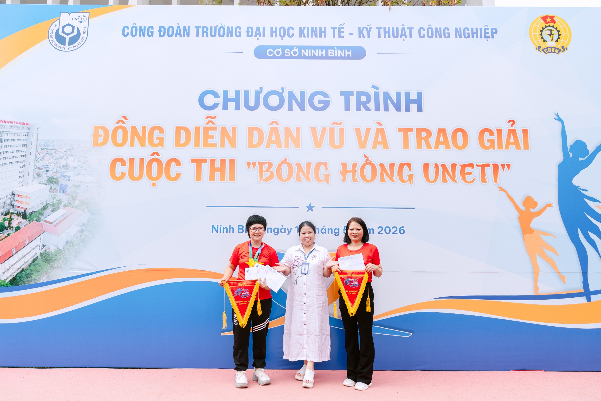 A group of people standing in front of a sign Description automatically generated