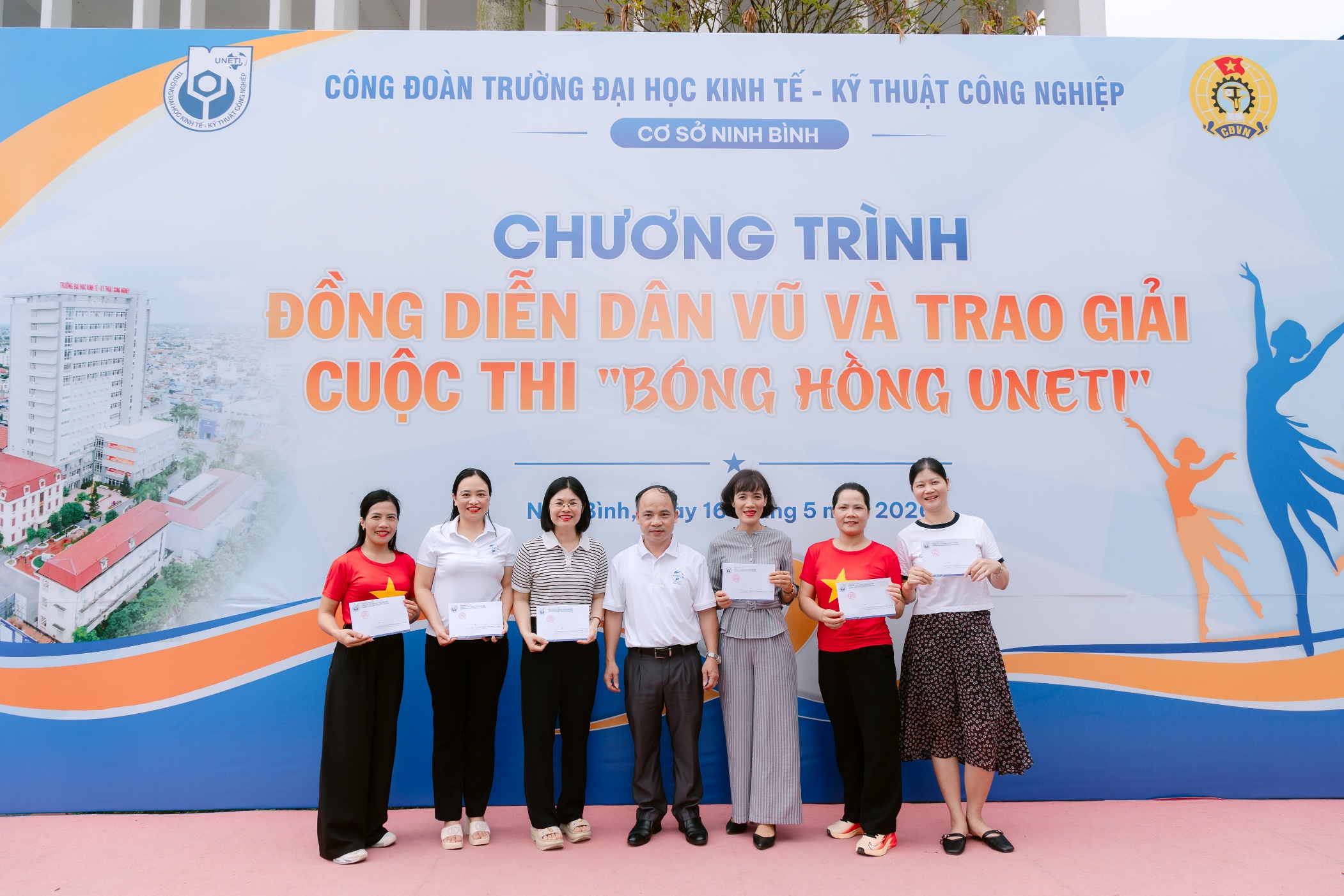 A group of people standing in front of a sign Description automatically generated