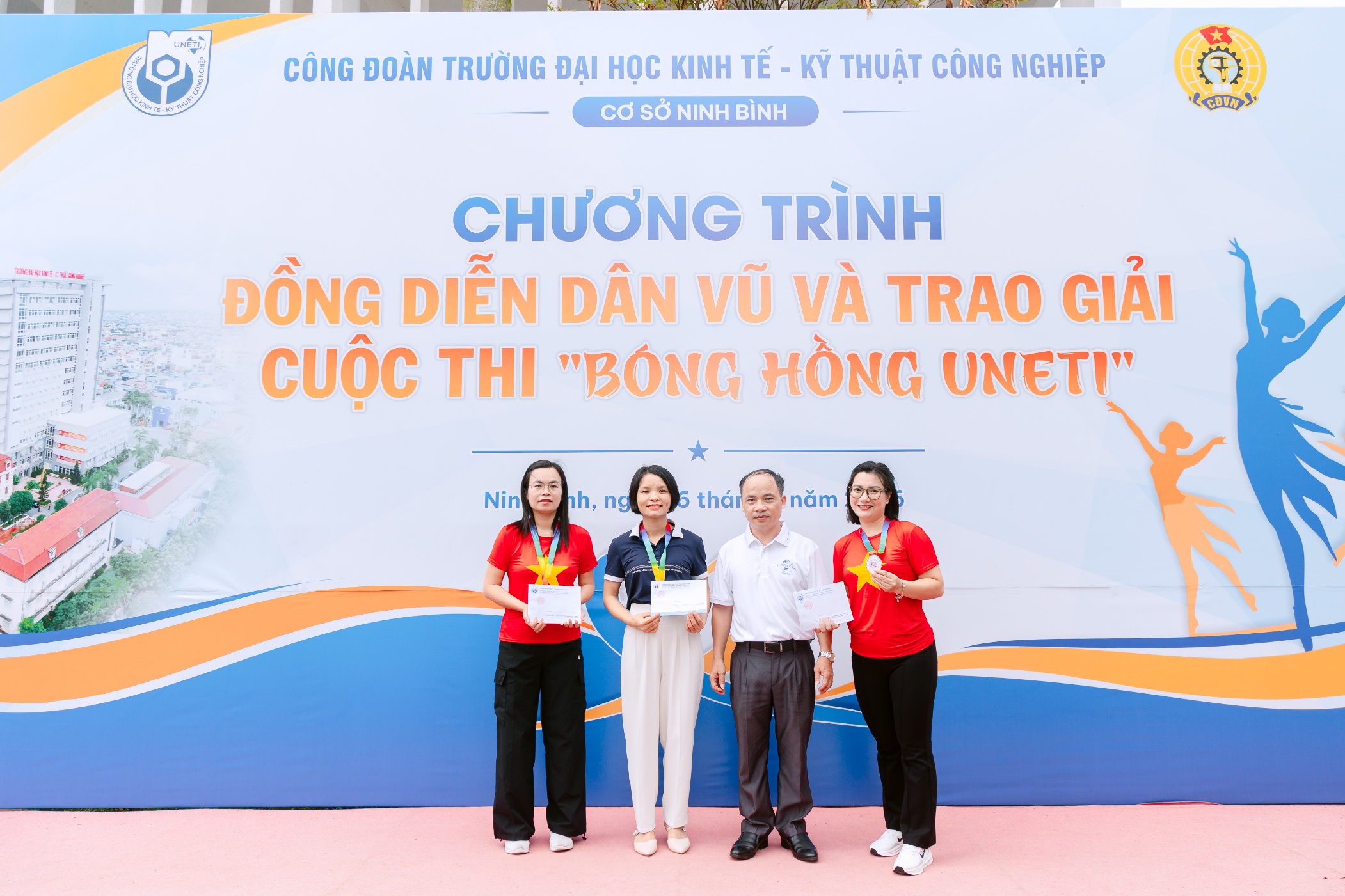 A group of people standing in front of a sign Description automatically generated