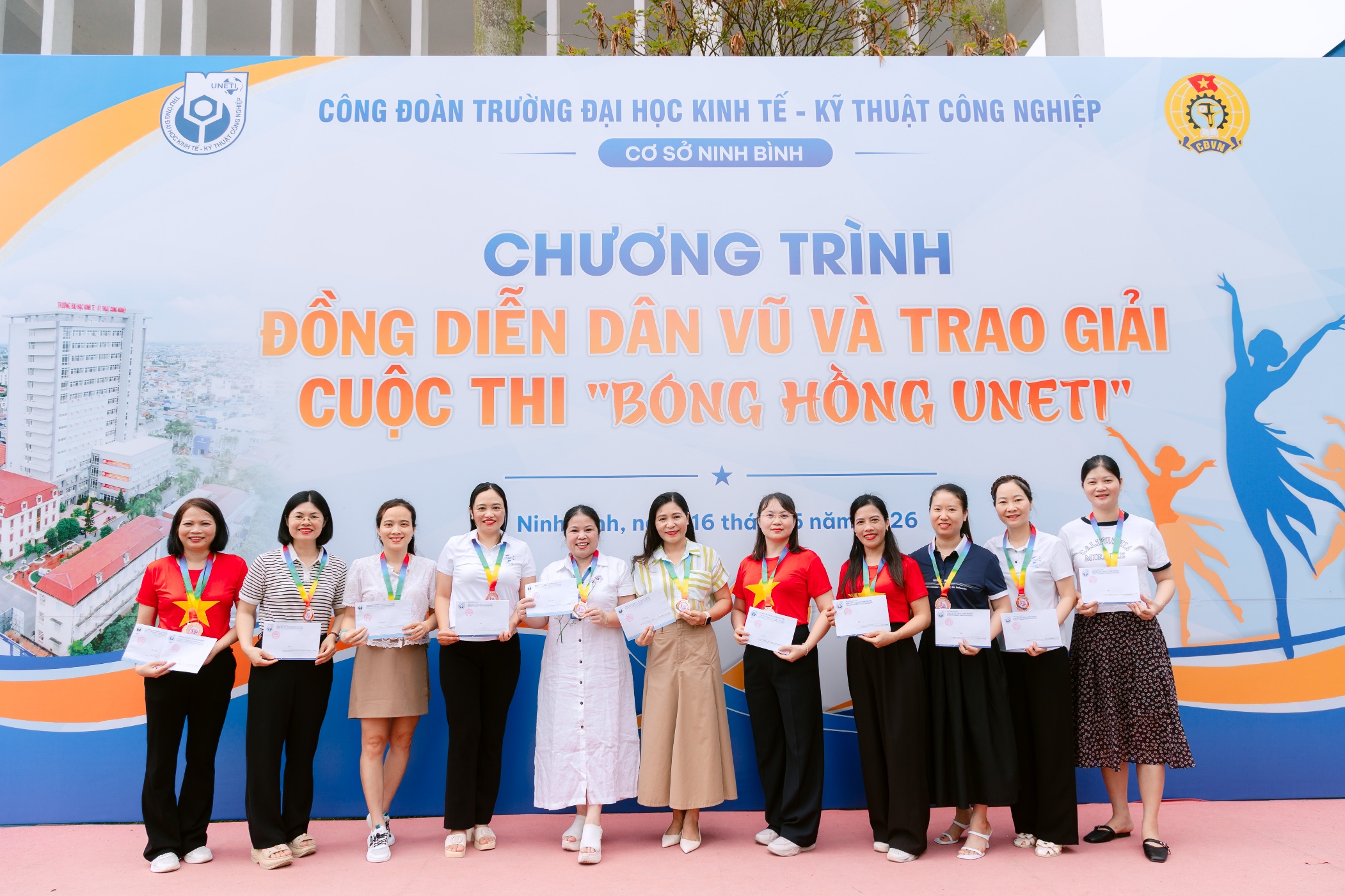 A group of people standing in front of a sign Description automatically generated