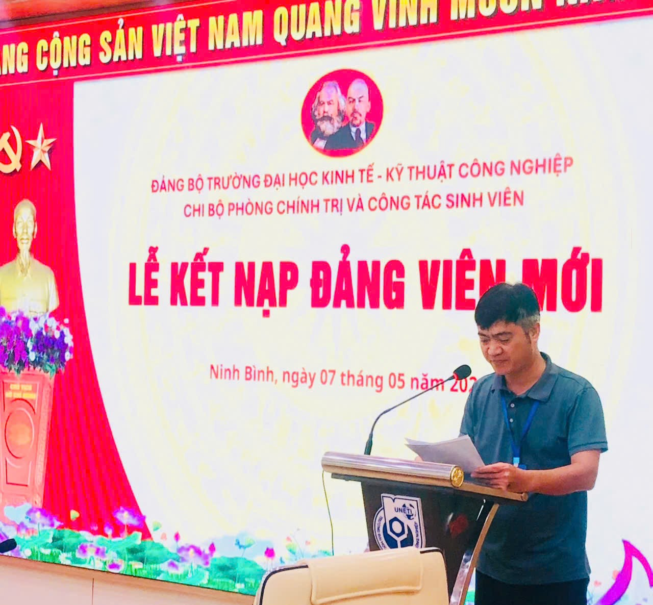 A person standing at a podium with a paper on it
Description automatically generated