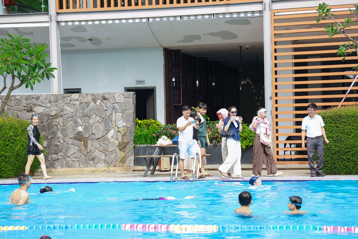 A group of people standing in a pool Description automatically generated
