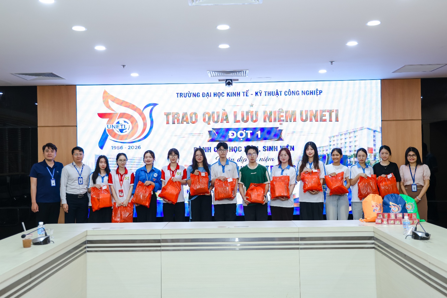 A group of people standing in front of a large sign
Description automatically generated