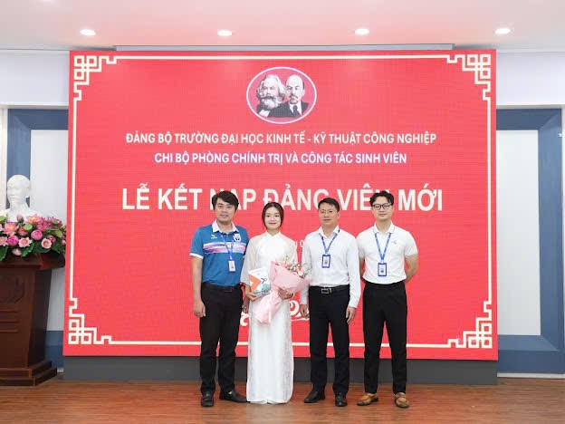 A group of people standing in front of a large sign
Description automatically generated