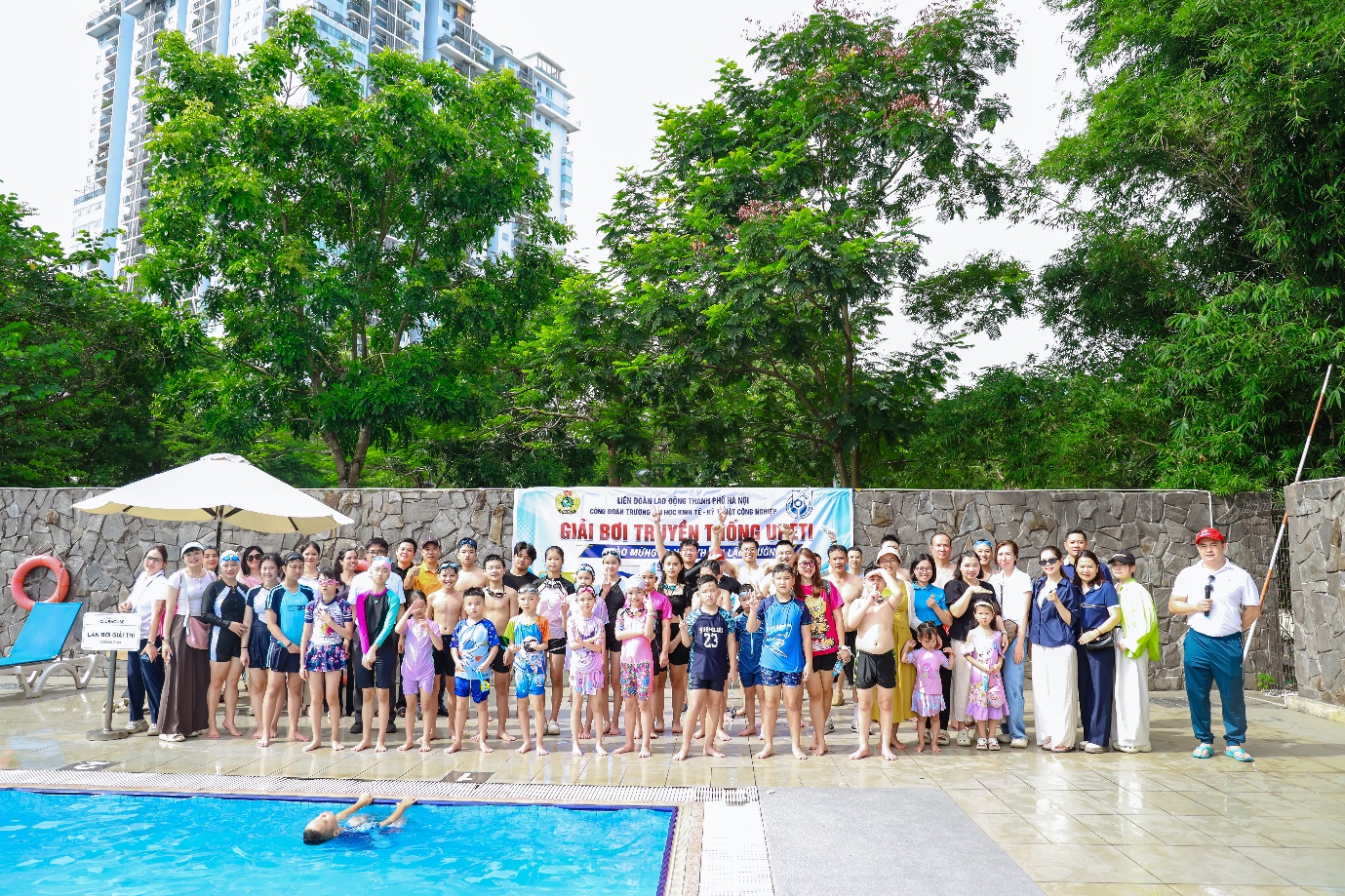 A group of people standing in front of a pool Description automatically generated