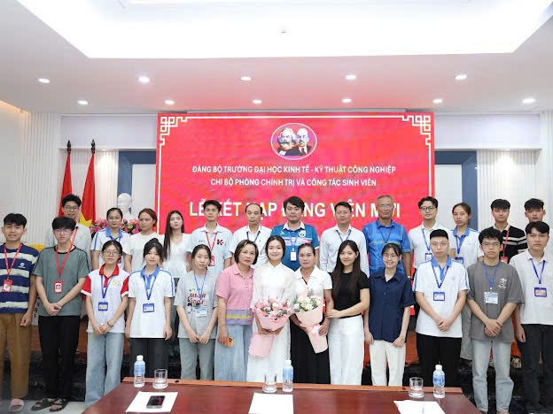 A group of people standing in front of a red banner
Description automatically generated