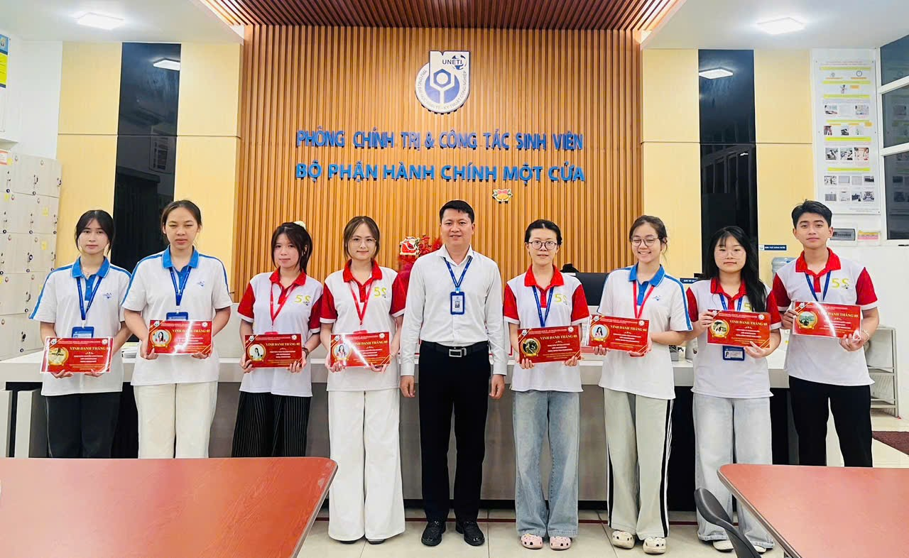 A group of people standing in front of a sign Description automatically generated