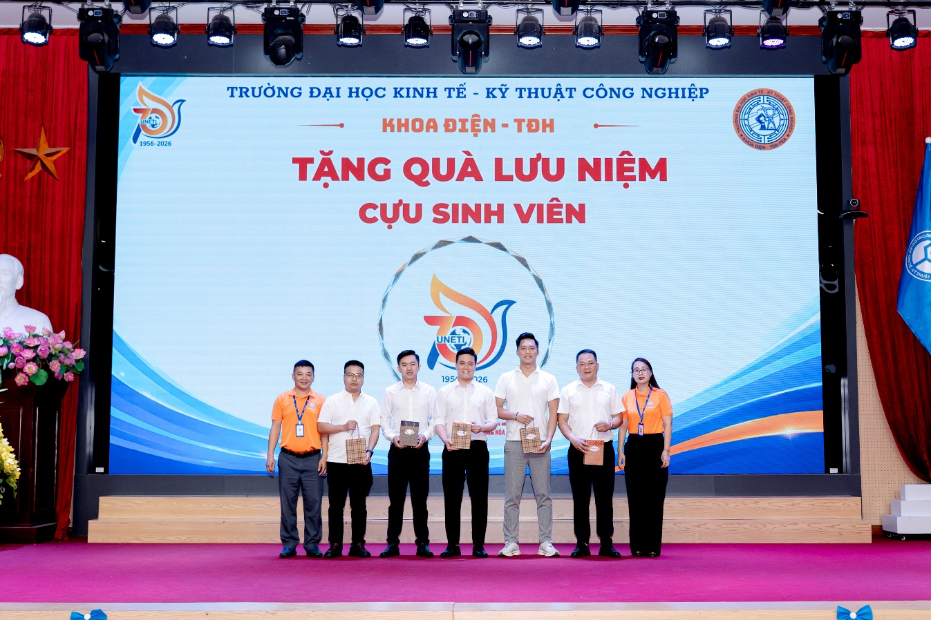 A group of people standing on a stage

Description automatically generated