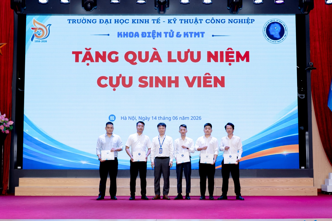 A group of people standing on a stage

Description automatically generated