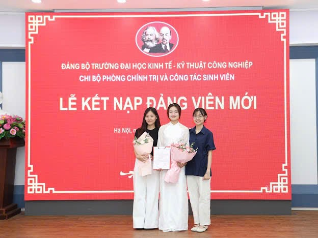 A group of women standing in front of a large sign
Description automatically generated