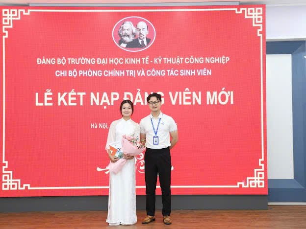 A person and person standing in front of a large sign
Description automatically generated