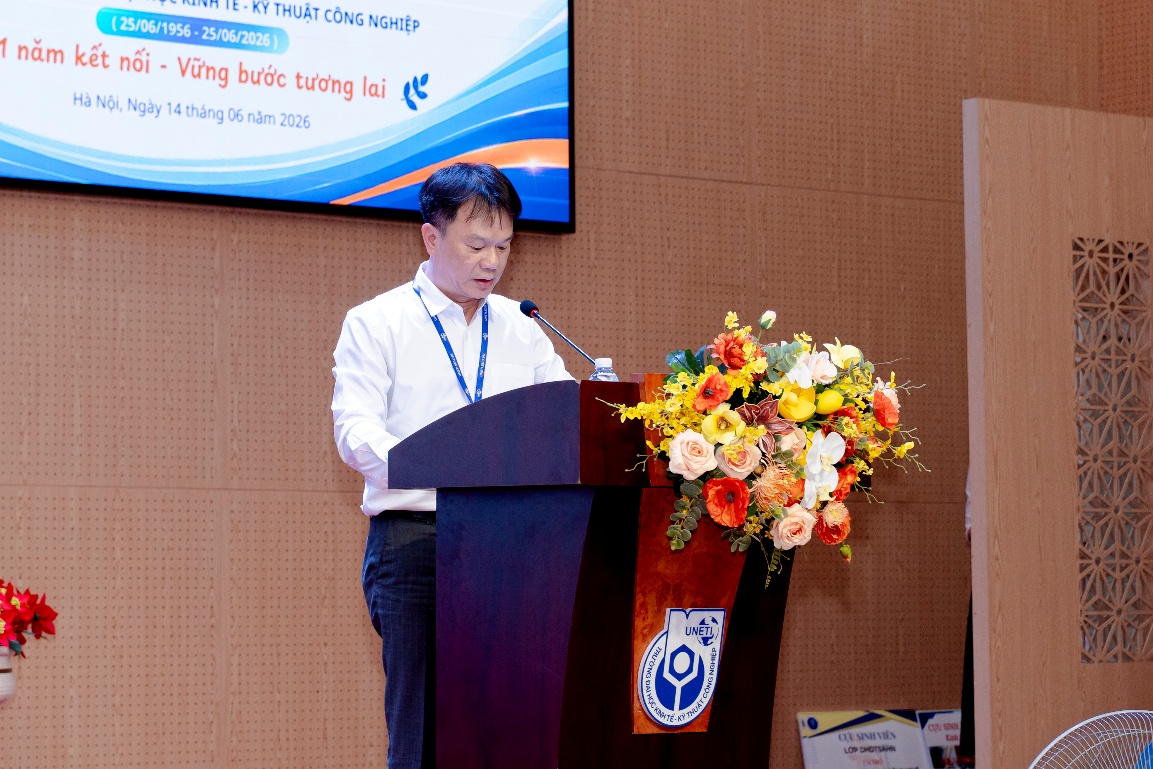 A person standing at a podium with a microphone and flowers

Description automatically generated