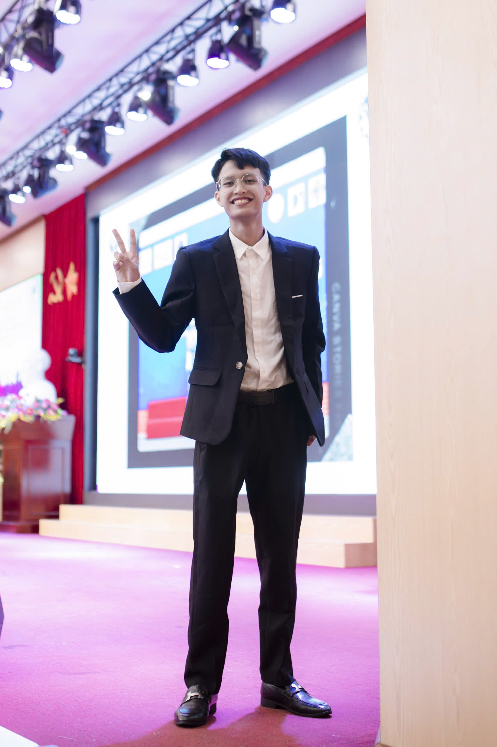 A person in a suit waving Description automatically generated